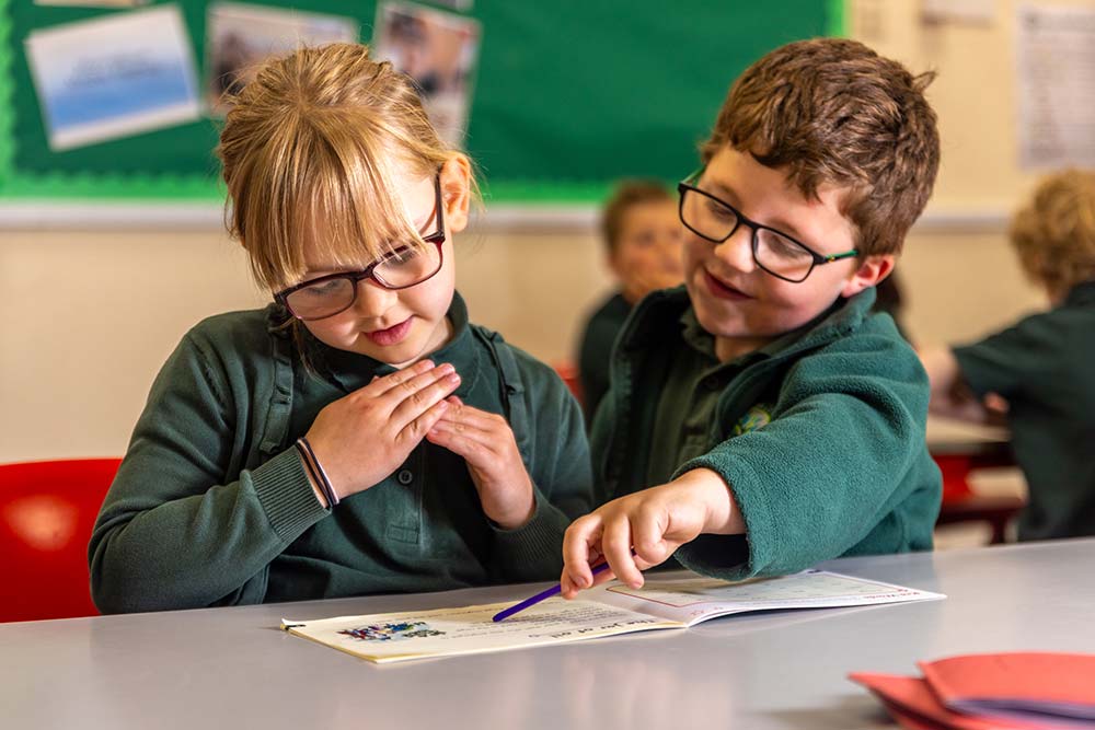 Oracy in school image, boy talking to girl. Boy and girl communicating with each other at Lostwithiel Primary